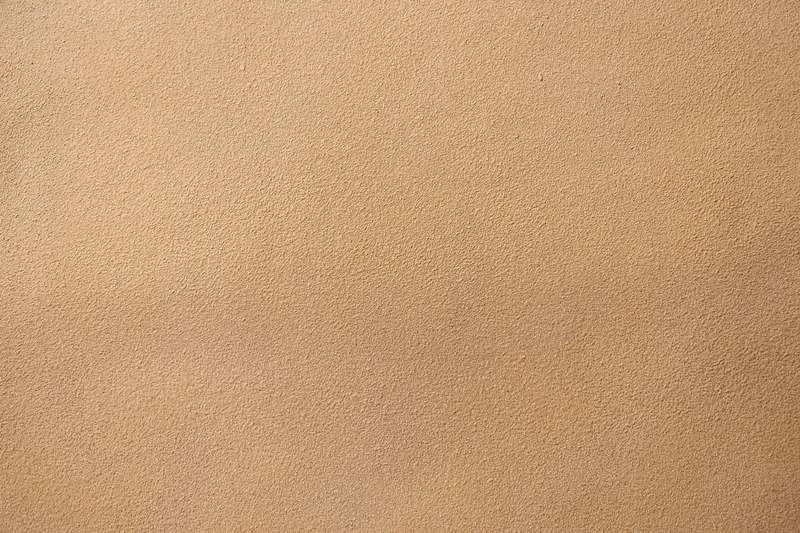 Close-up of assorted sandpaper sheets: coarse (40-grit), medium (120-grit), fine (220-grit), and ultra-fine (400-grit), laid on a clean workshop bench with calipers and a wood sample